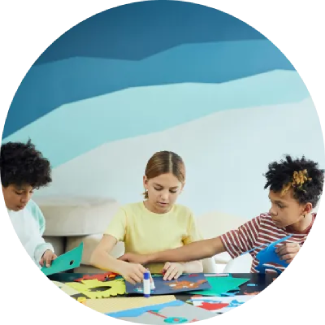 Three children engaged in arts and crafts at a table, fostering creativity and focus.