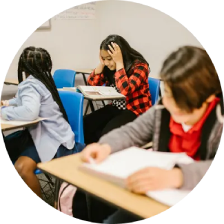 Students reading at desks in a classroom, creating a focused environment for learning and self-confidence.