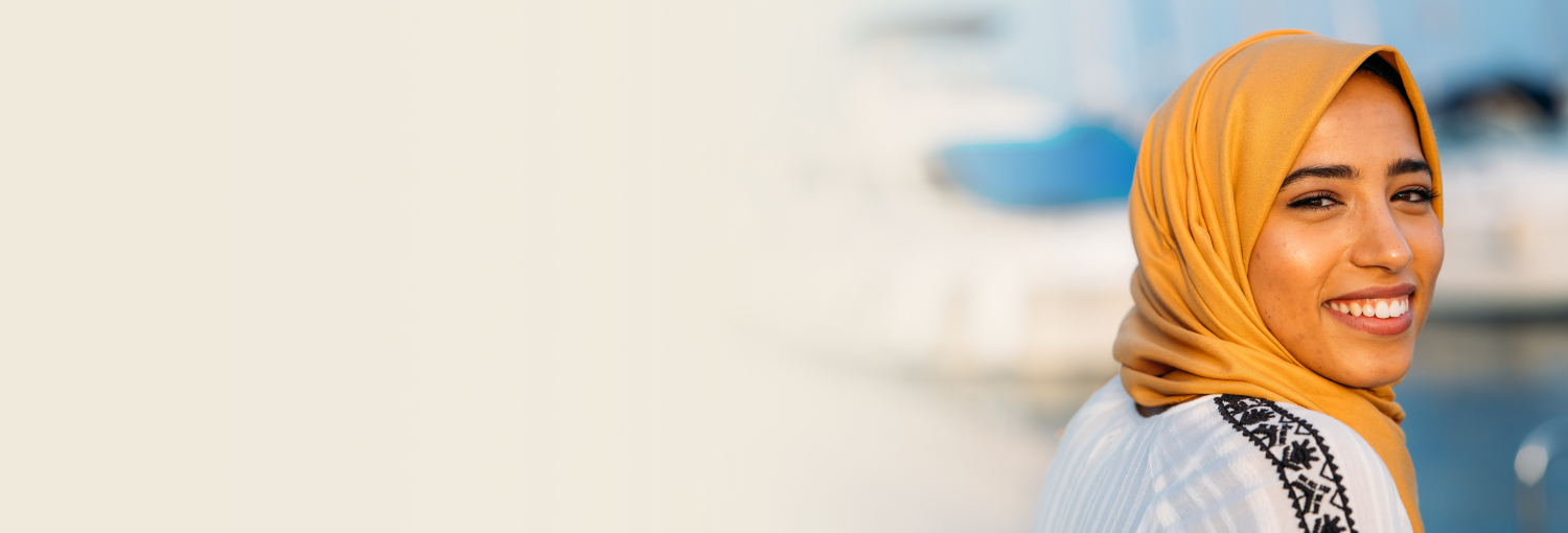 A woman in yellow hijab smiling brightly