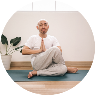 A man performing yoga asana with crossed legs and hands on namaste pose