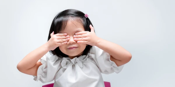 Young participant practicing intuition by closing her eyes with hands