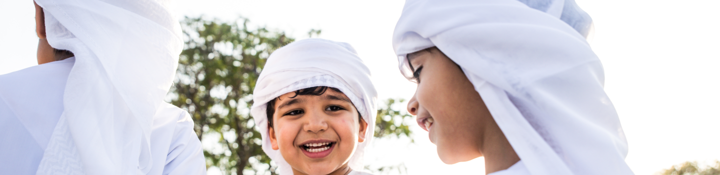 Kids in white thobe smiling with joy