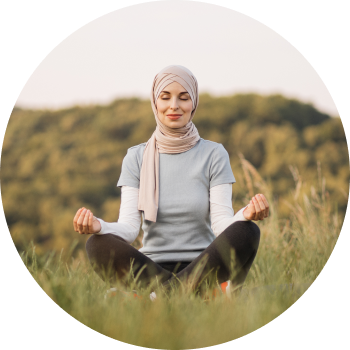 A smiling female with closed eyes meditating