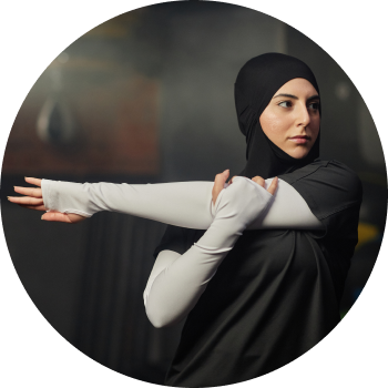 A woman in black hijab sports wear stretching her arms